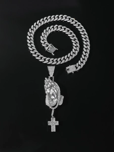 Close-up of hip-hop silver plated chain with iced out praying hands cross pendant