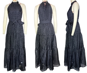 Detail view of black halter neck dress featuring tiered skirt and textured plaid fabric