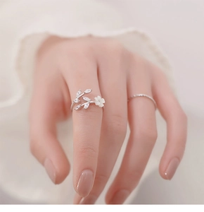 Detail of adjustable silver flower ring with white petals and marquise zircon leaves