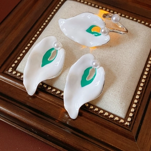 Detail of vintage enamel calla lily jewelry set with pearls and green accents