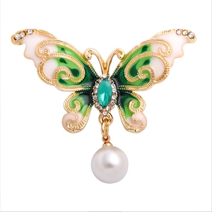 Elegant gold butterfly brooch with green enamel wings, rhinestones and pearl drop pendant