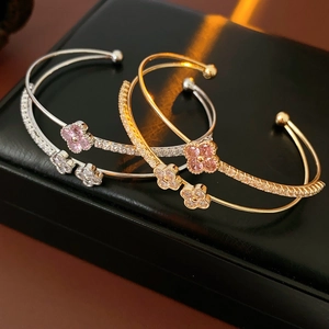 Detail of clover double-layer open bracelets with zircons on a leather jewelry box