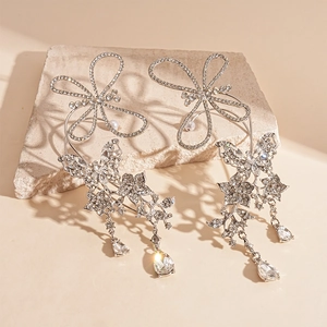 Macro shot of silver butterfly ear cuffs with sparkling crystals on a textured stone