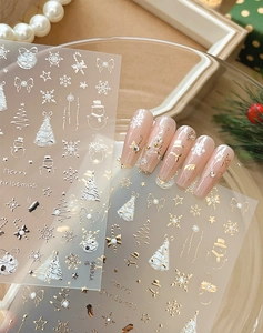 Detail of Christmas nail stickers with gold bow and snowman patterns on festive background