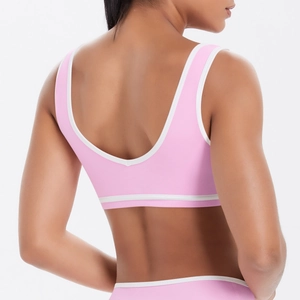 Détail du dos d'une brassière de sport rose avec bordures blanches et bande large de soutien