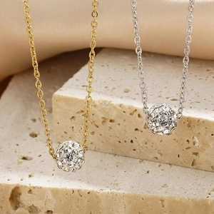 Elegantes Set aus gold- und silberfarbenen Pavé-Kugelketten auf Naturstein-Hintergrund