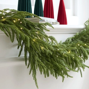 Faux Christmas garland with warm LED lights draped on a white fireplace mantle