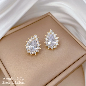 Detail view of pear-cut zircon earrings with gold plating and paved small crystals