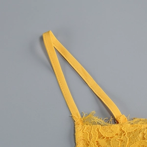 Dettaglio del ricamo in pizzo giallo e del delicato attacco della spallina sul top