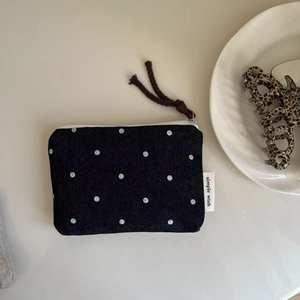 Macro detail of navy denim polka dot coin purse with zipper and simple wish label