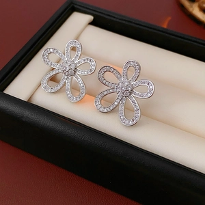 Gros plan de boucles d'oreilles fleurs en argent avec zircon dans un écrin noir