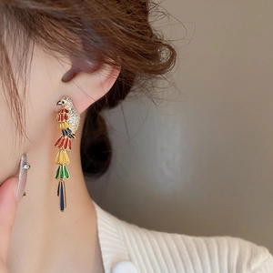 Close-up of parrot drop earring with colorful enamel and long tassels on model