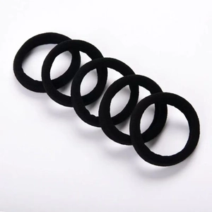 Close-up of five seamless black elastic hair ties set in a minimalist professional layout