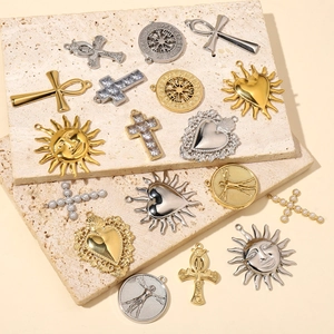 Assorted gold and silver stainless steel pendants with cross, sun, and heart designs