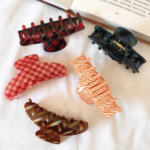 French acetate checkered hair claws set in various colors on a white cloth background