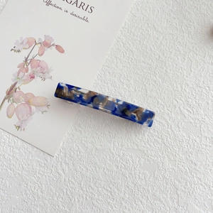 Close-up of rectangular blue marble acetate hair clip with silver metal spring fastener
