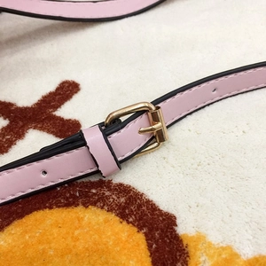 Detail of pink PU leather shoulder strap with golden adjustable buckle and black edge oil