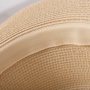 Close-up of the woven paper texture and internal sweatband of a women's summer sun hat
