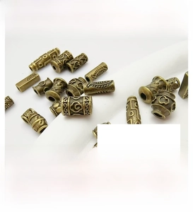 Detailed view of antique bronze alloy spacer beads with intricate cloud and feather reliefs