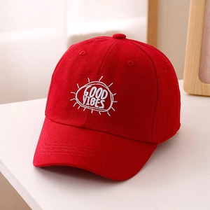 Dettaglio del cappellino rosso per bambini con ricamo Good Vibes e cotone traspirante