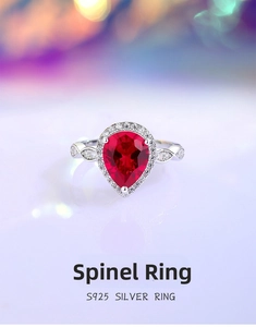 Macro shot of S925 silver ring featuring a pear-cut red gemstone and halo diamonds