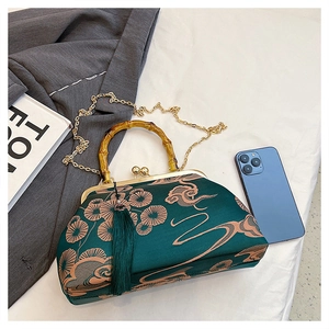 Detail der dunkelgrünen Sticktasche mit Bambusgriff und goldener Kettenriemen