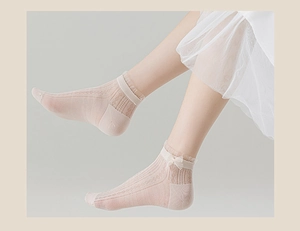 Detail of pink mesh lace socks featuring sweet bow ornaments and breathable fabric