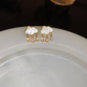 Macro shot of gold cloud earrings with white pearl texture and zircon raindrops