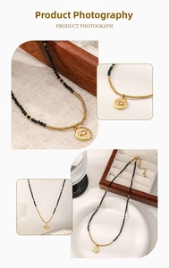 Detail of beaded evil eye necklace featuring black spinels and a gold pendant close-up