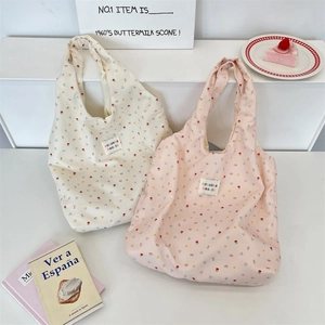 Detailed close-up of floral cotton tote bags with stylish brand labels and soft patterns