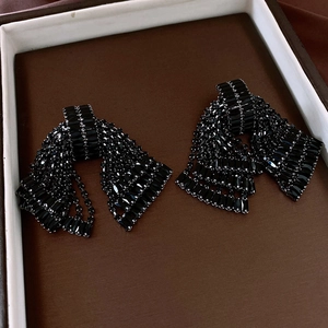 Detailed view of black rhinestone tassel earrings with geometric crystal settings