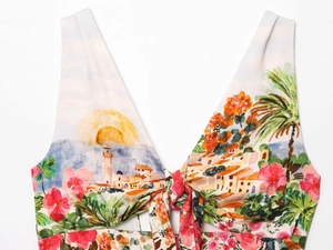 Detail of colorful landscape print on floral tie-front top with fabric texture