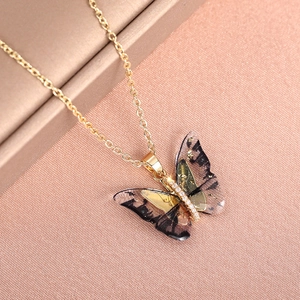 Detail of a 3D butterfly necklace with gold foil accents and sparkling cubic zirconia