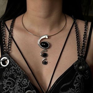 Detail of silver collar necklace with spiral pendant and black resin gemstones