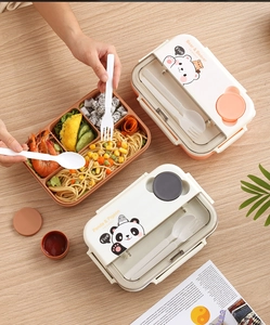 Close-up of a 4-compartment bento lunch box with built-in cutlery and cute panda patterns