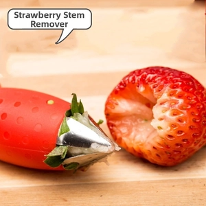 Macro detail of a red strawberry huller removing a fruit core on a wooden board