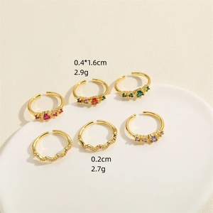 Lot de 6 bagues ondulées plaquées or 14K avec zircons colorés sur plateau céramique