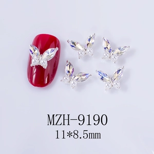 Macro view of butterfly nail charm with silver frame and crystals on red manicure