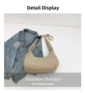 Vue détaillée d'un sac demi-lune matelassé beige avec sangle réglable sur du denim