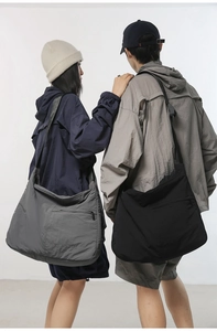 Dual-model view of large nylon messenger bags showing spacious capacity and adjustable straps