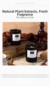 Aromatherapy scented candle in black glass jar placed on vintage books and dried pine cones