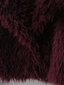 Macro detail of deep purple faux fur texture showing soft plush and glossy long hair