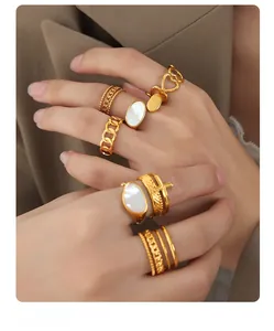 Close-up of gold plated ring set with mother of pearl and hollow heart patterns