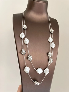 Detail of double-layer necklace with irregular white pearls and silver metal beads