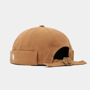 Detailed view of brown canvas brimless cap featuring retro 'N' embroidery and metal buckle