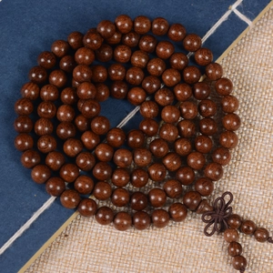 Detailed macro view of spiral-wrapped sandalwood prayer beads with natural wood grain