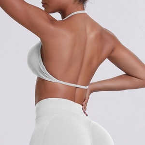 Detail view of white seamless ribbed yoga set showing halter neck bra and high waist leggings