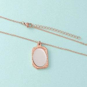 Detail van een roségouden ovale hanger met gehamerde randen en een glad spiegelend oppervlak