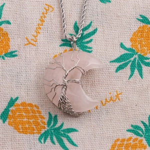 Detail of crescent pink crystal necklace with silver wire tree of life on twist chain
