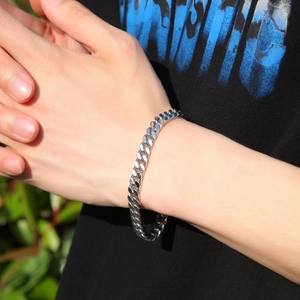 Close-up of polished silver Cuban link bracelet with spring clasp on male wrist